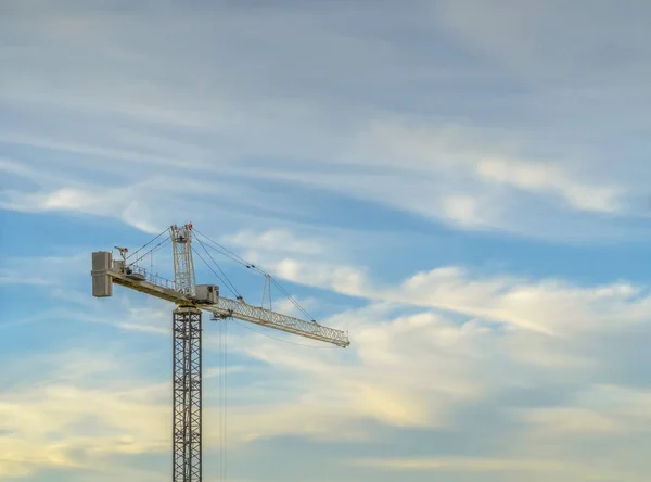 Uma torre guindaste contra um belo arranha-céu — Fotografia de Stock