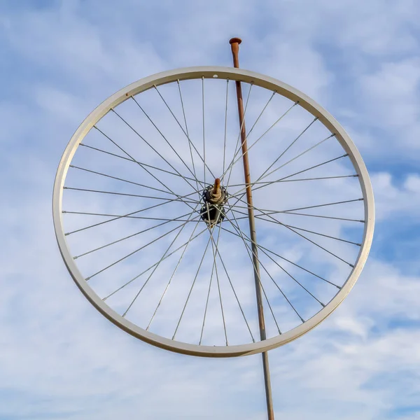 Borda de roda de bicicleta em um pólo contra o céu nublado — Fotografia de Stock