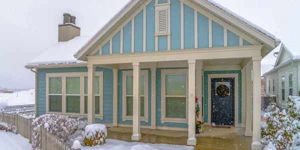 stock image Blue home with snowy yard and fence in December