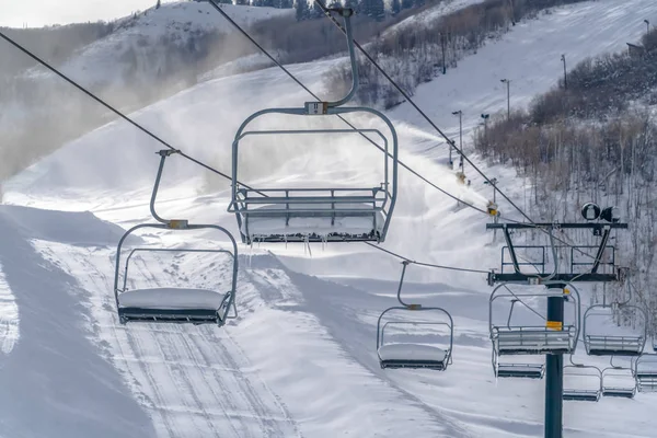Συρόμενοι αναβατήρες πάνω από το χιονισμένο βουνό και χιόνι κανόνια — Φωτογραφία Αρχείου