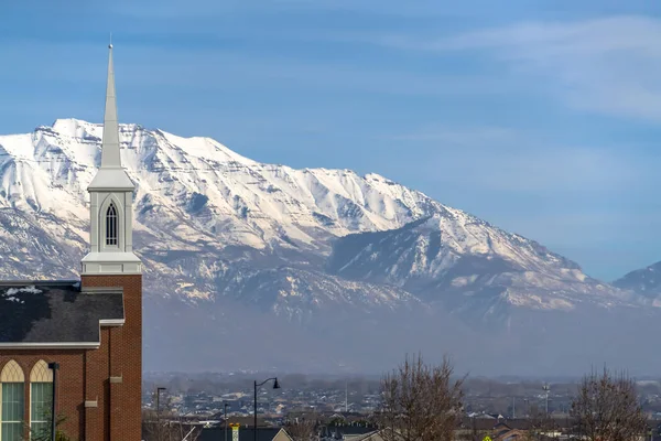 Church and homes against Mount Timpanogos and sky