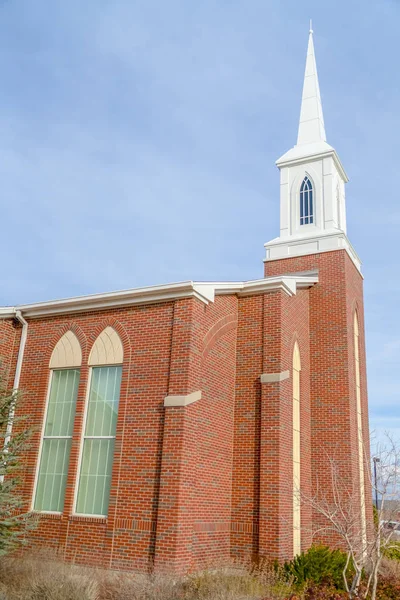 Церковь с арочными окнами и белым шпилем — стоковое фото