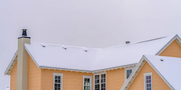 夜明けの冬の雪に覆われた屋根の家 — ストック写真