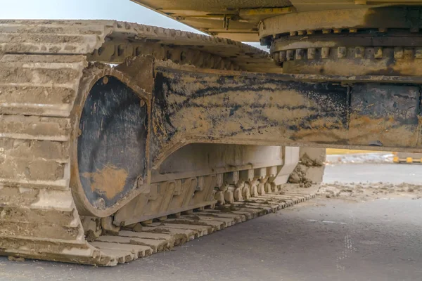 Excavator with caked mud on the grouser pad