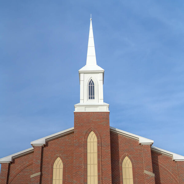 Exterior of a sunlit church against vast blue sky