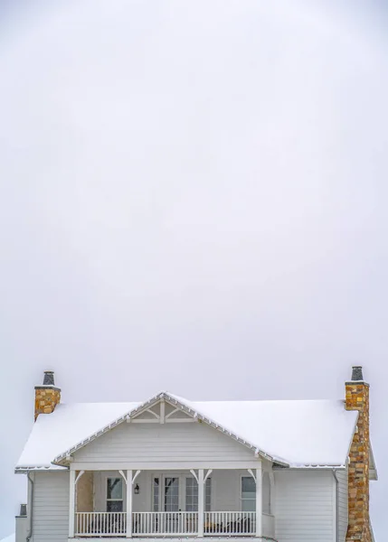 Casa con balcón y techo cubierto de nieve contra el cielo vasto — Foto de Stock