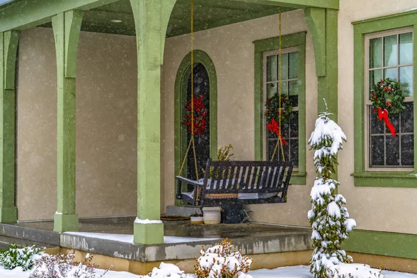 Home with porch swing and welcoming wreaths