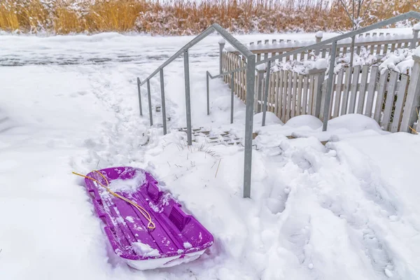 Slitta viola accanto a una scala esterna in inverno — Foto Stock