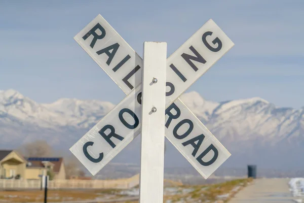 Railroad Crossing sign against a snowy mountain