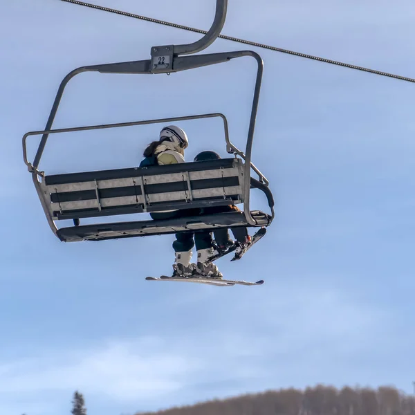 Skilift mit Frau und Kind gegen blauen Himmel — Stockfoto