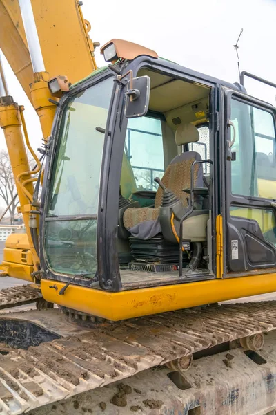 The cab and dirty grousers of a yellow excavator — Stock Photo, Image