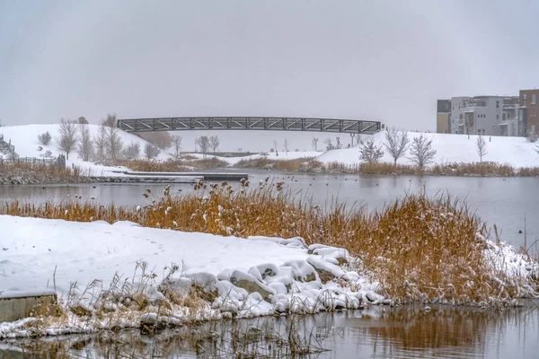 Puente y cubierta en un lago rodeado de nieve — Foto de Stock