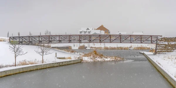 Puente sobre el lago con costas nevadas en invierno — Foto de Stock