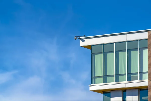 Building exterior with security camera against sky