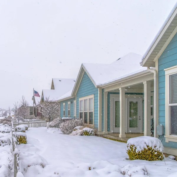 Homes with snow covered roofs and yards in winter