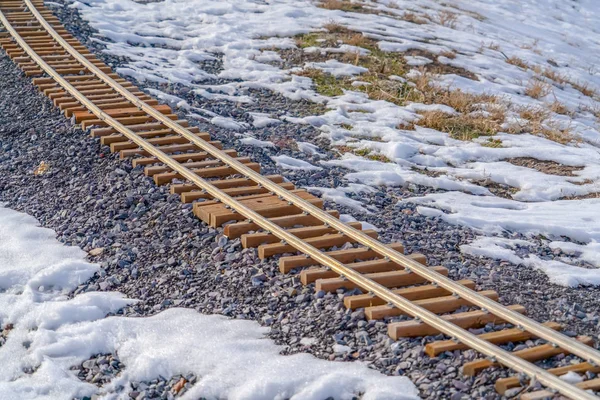 Spoorweg track op een rotsachtige en besneeuwde grond — Stockfoto