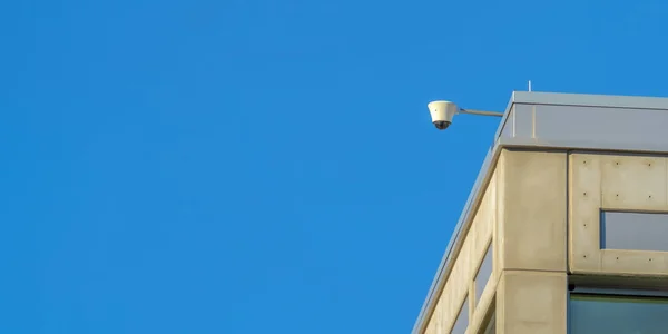 Câmera de segurança de um edifício com fundo céu — Fotografia de Stock