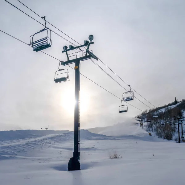 Αναβατήρες για σκι ενάντια στο βουνό και τον ήλιο στο πάρκο πόλης — Φωτογραφία Αρχείου