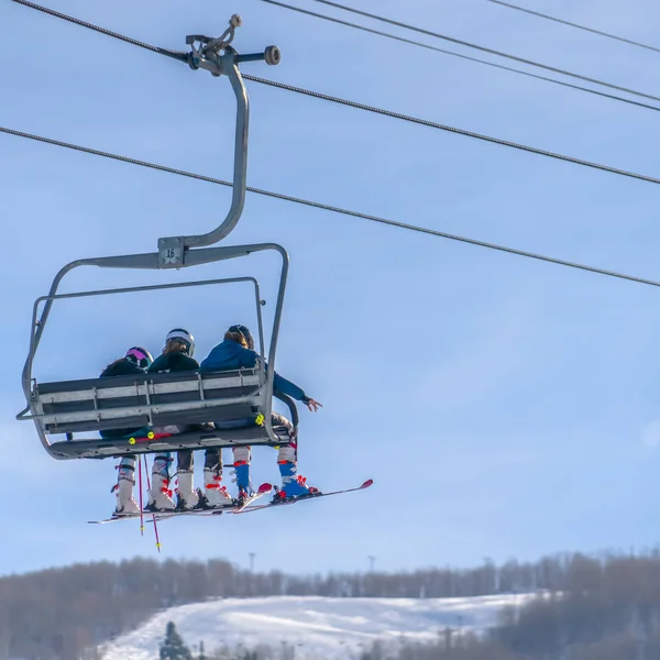 Skiers on ski lift with sky and mountain view — Stock Photo, Image