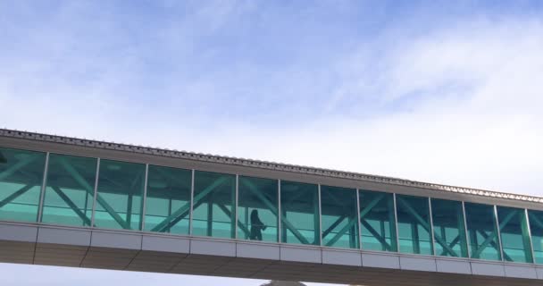 Blå himmel bakom gångbro mellan byggnader — Stockvideo