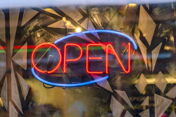 Neon Open sign on decorated glass surface