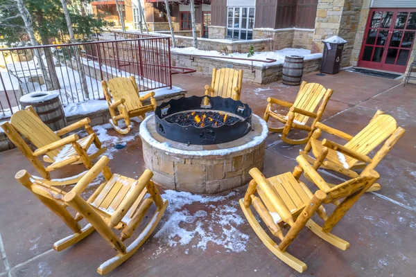 Patio with wooden rocking chairs around a fire pit