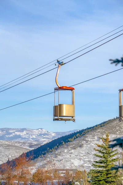 Лыжные подъемники против гор и неба в сытный день — стоковое фото