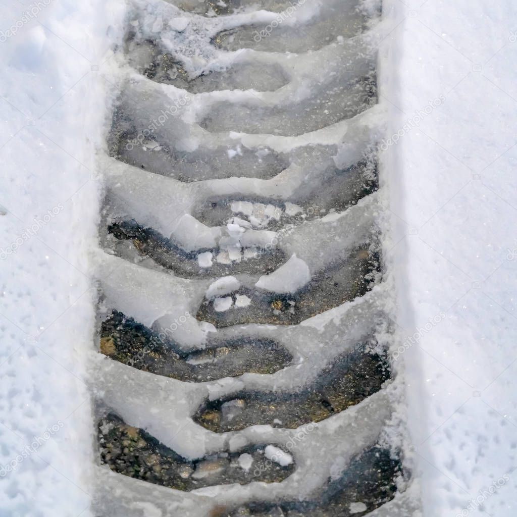 Tire tracks on snow covered road in winter