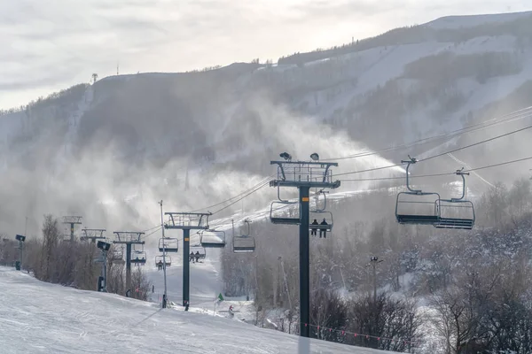 Σκιέρ σε λιφτ του σκι με θέα στο γραφικό χιονοδρομικό θέρετρο — Φωτογραφία Αρχείου