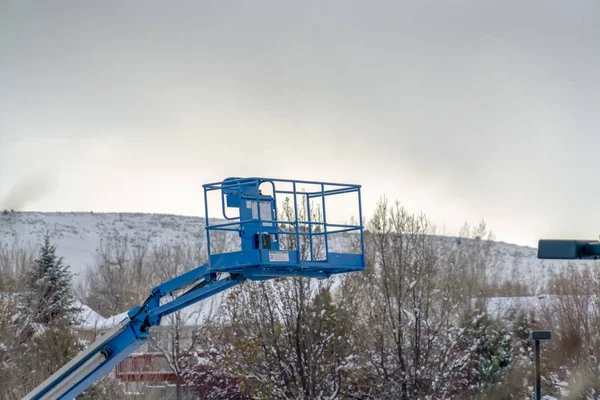 Boom lift against mountain and sky in winter