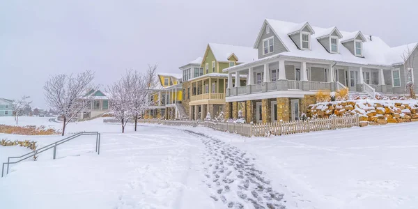 Fußabdrücke auf Schnee gegen Häuser und Himmel im Winter — Stockfoto