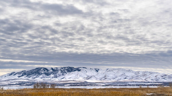 Clear Panorama Dramatic sky filled with cottony clouds over a scenic landscape in winter