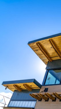 Güneşli bir günde açık mavi gökyüzü altında düz çatı ve kırmızı tuğla duvar ile Açık Dikey Bina