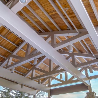 Ağaçlara ve bulutlu mavi gökyüzüne karşı içeriden görülen bir köşkün Clear Square Çatı