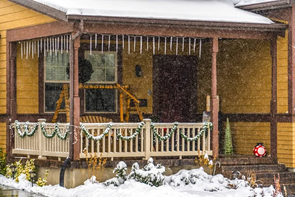 Rustic brown home in Daybreak Utah viewed through falling snow in winter Royalty Free Stock Photos