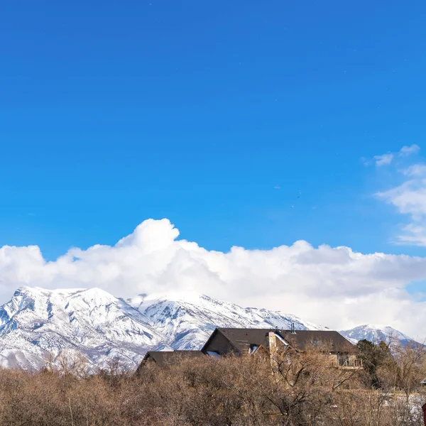 Borrar Plaza Magnífica montaña cubierta de nieve contra un cielo vivo con nubes hinchadas — Foto de Stock