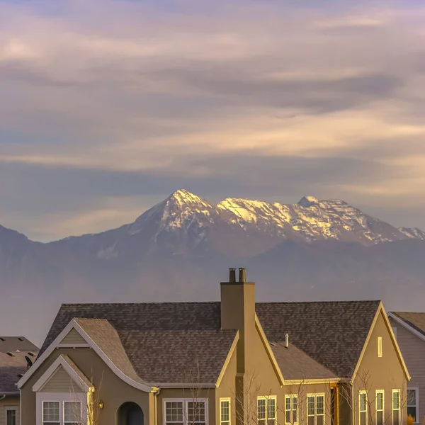 Fachada cuadrada de una casa vista contra una montaña nevada en el fondo —  Fotos de Stock