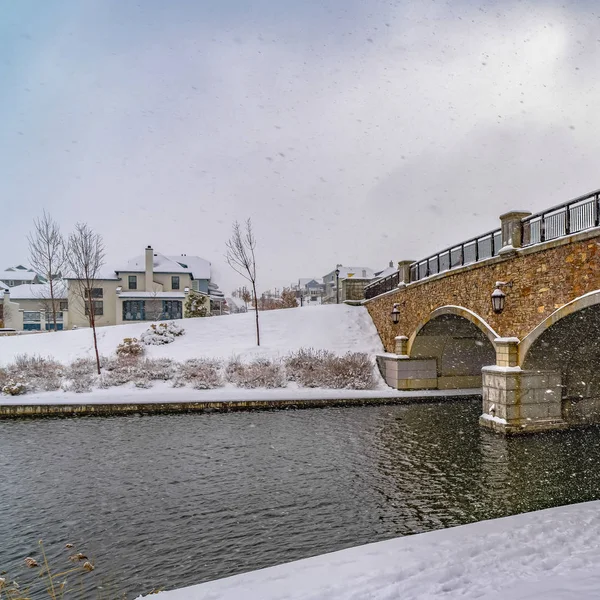 Plaza Paisaje nevado de un lago con puente contra el cielo nublado en Daybreak Utah — Foto de Stock