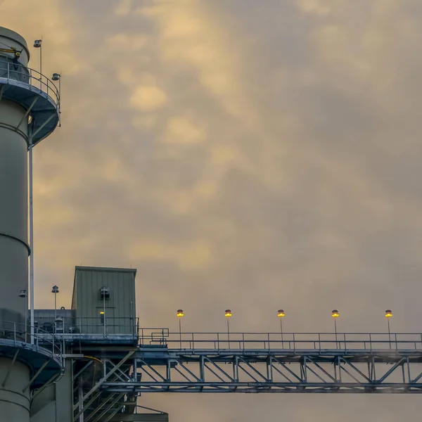 Τετράγωνο εργοστάσιο ενέργειας στην κοιλάδα της Γιούτα ενάντια στον απέραντο ουρανό με πρησμένα σύννεφα στο ηλιοβασίλεμα — Φωτογραφία Αρχείου