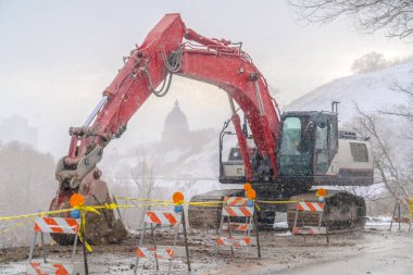 Arka planda Utah State Capital Building ile bir dağ yolu üzerinde Ekskavatör