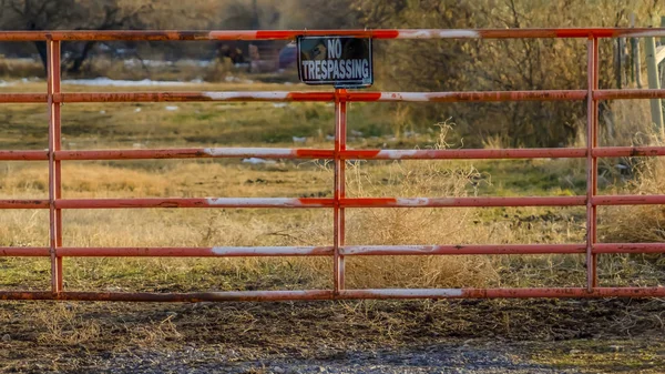 Jasne Panorama No Trespassing znak na bramie prywatnej nieruchomości oglądany w słoneczny dzień — Zdjęcie stockowe