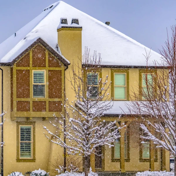 Clear Square Winter home with frosty trees on the snow covered front yard in Daybreak Utah