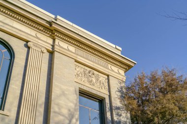 Güneşli bir günde berrak mavi gökyüzünü yansıtan cam pencerelerle bina