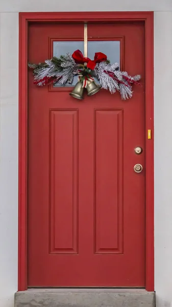 Pionowe drzwi przednie z panelem szklanym i dekoracją świąteczną przed prążkacją białej ściany — Zdjęcie stockowe