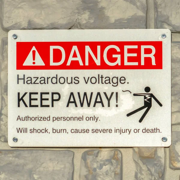 Square Close up of Danger Hazardous Voltage Keep Away sign posted on a gray surface — Stock Photo, Image