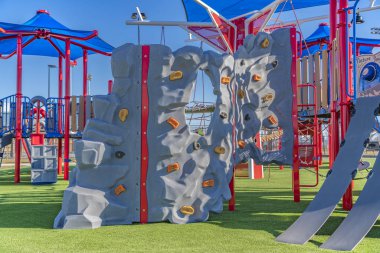 Playground equipment at a park under blue sky on a sunny day clipart