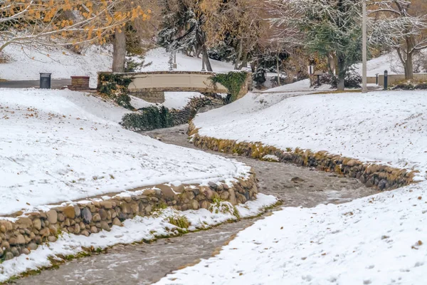 Arroyo y puente en un hermoso parque cubierto de nieve en Salt Lake City en invierno — Foto de Stock