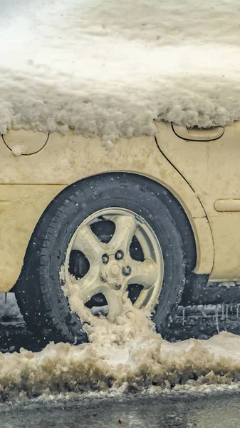 Coche blanco vertical cubierto de nieve en una carretera helada y húmeda en Daybreak Utah — Foto de Stock