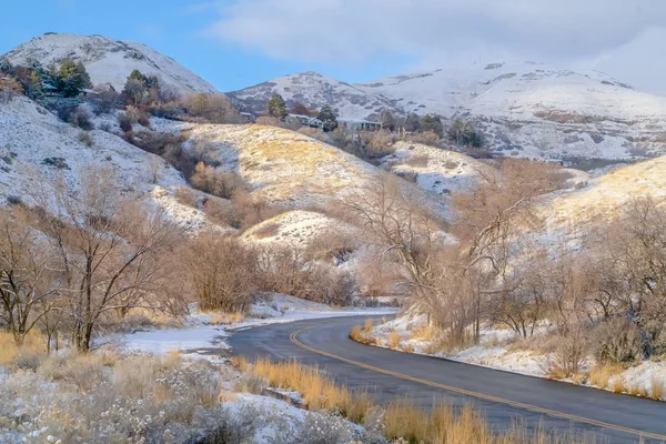 Carretera y casas en la montaña nevada soleada en invierno — Foto de Stock