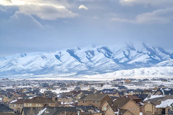 Casas con una montaña nevada y cielo nublado vista en invierno — Foto de Stock